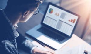 a screenshot of a trader in front of a computer screen with trading charts for the best futures brokers in the UK story