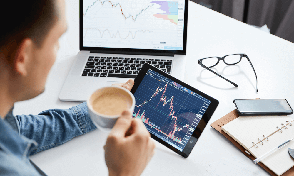 trader looking at MT5 trading platform charts on computer screen and tablet